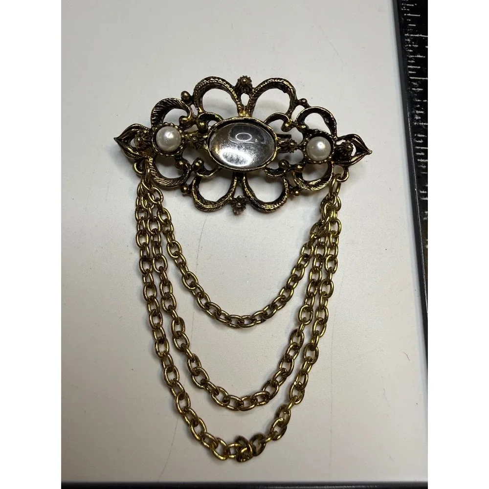 Ornate Gold Tone Filigree Brooch Faux Pearls Clear Cabochon and Triple Chain